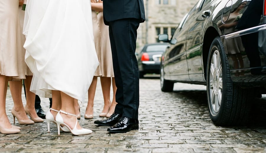 Wedding party leaving the venue in a stretch limousine at night